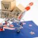 Shopping cart import export and stethoscope on New Zealand flag.