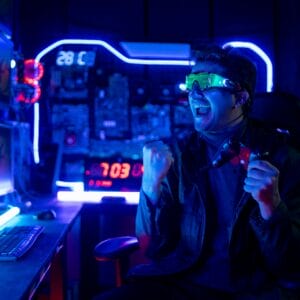 Gamer man with hitech clothes and eye glasses show action of excited and happy during play game