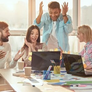 Shocked colleagues looking at laptop.