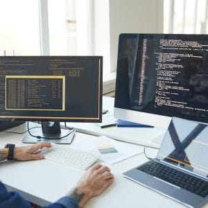 IT Programmer Writing Code on Computer Screen