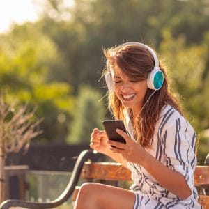 Woman wearing headset listening to the music outdoors